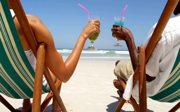 Couple toasting glasses of cocktails at beach. Couple relaxing together at beach 4k